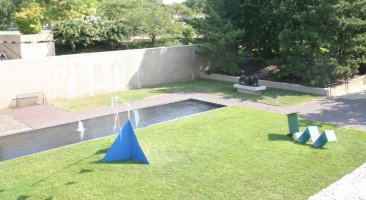 Blue triangular mobile in sculpture garden