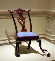 Chair with one leg "reaching" for a caster that has come loose