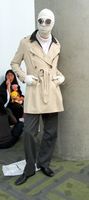 Man in beige raincoat, wrapped up like the invisible man.