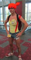 Man in drag with bright orange wig and yellow tank top