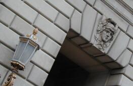 Lamp and sculpted head on building