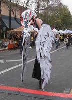 Woman on stilts with bird head and wings